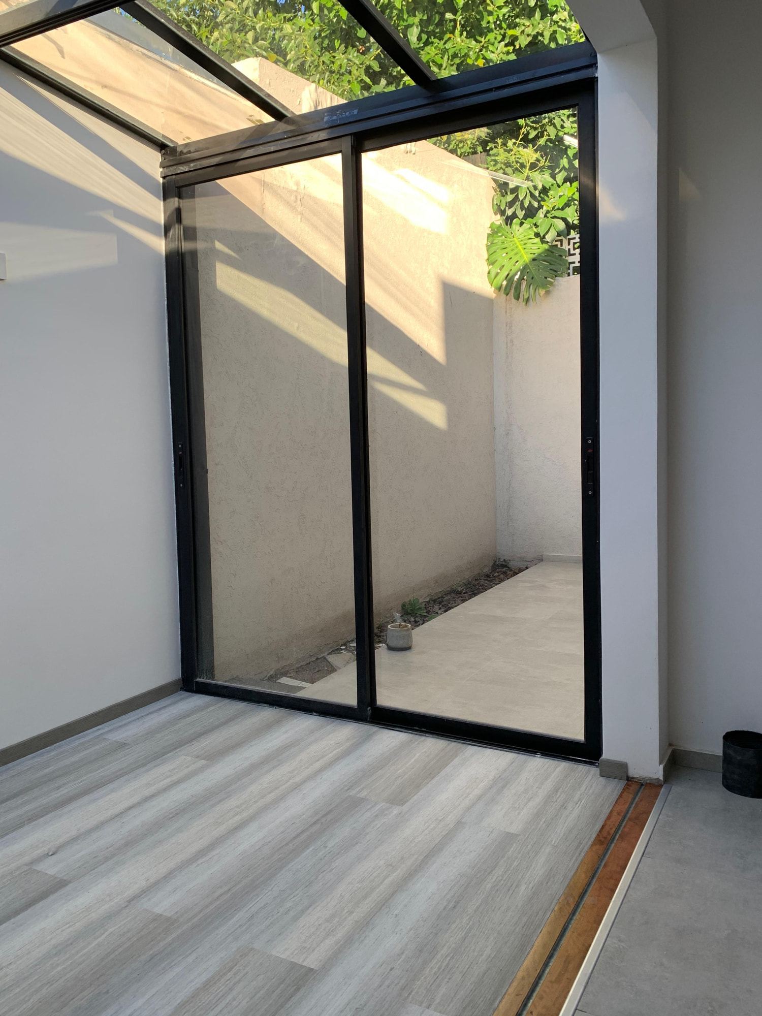 Site photograph of the same space, with the glass roof and the frames already installed.